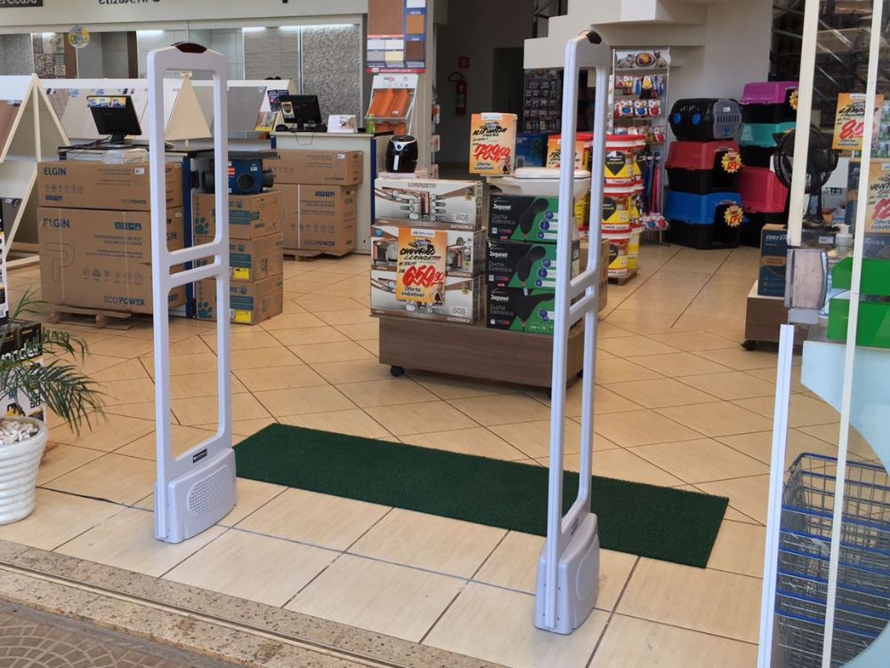 Antenas antifurto posicionadas em loja, ilustrando como verificar o sistema se o alarme de loja apitar.