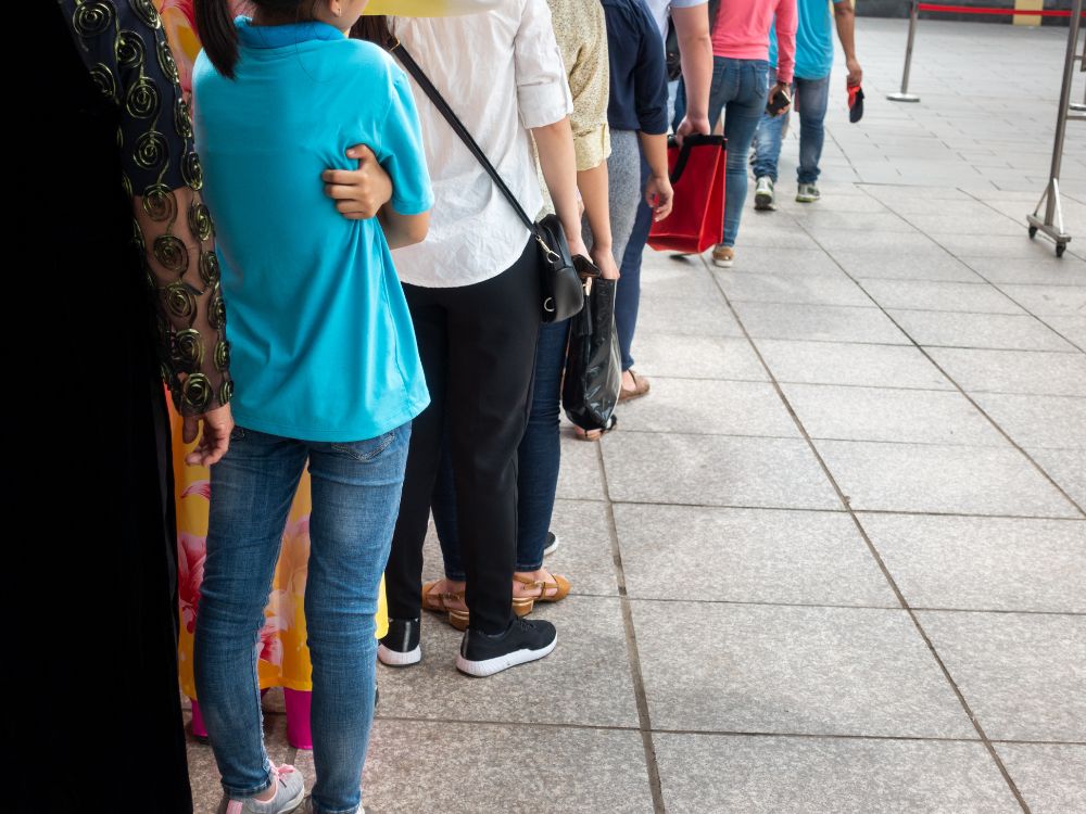 Consumidores aguardando atendimento em fila convencional, representando um dos tipos de fila de espera mais comuns no varejo.